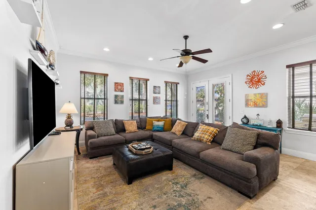 a living room with furniture ceiling fan and a flat screen tv