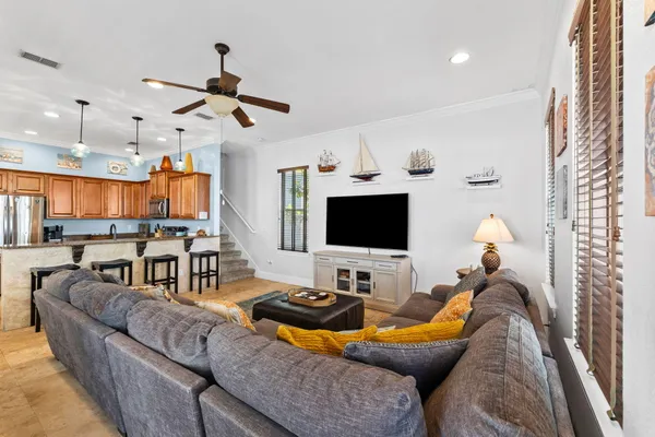 a living room with furniture kitchen view and a flat screen tv