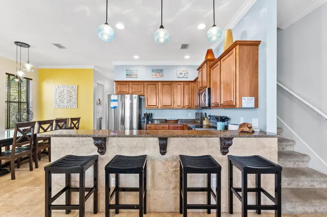 a kitchen with granite countertop a table chairs stove and cabinets