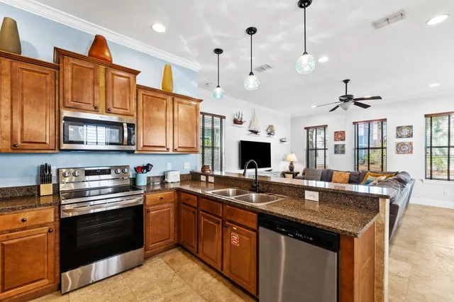a kitchen with stainless steel appliances granite countertop a sink a stove and a refrigerator