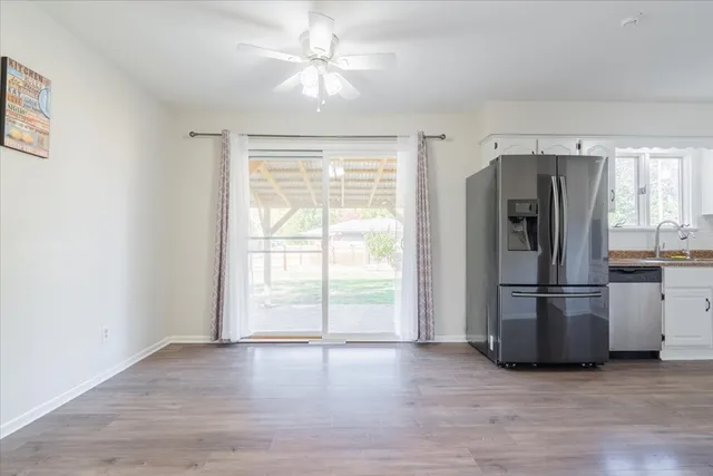 a view of a kitchen with a stove fridge and wooden floor