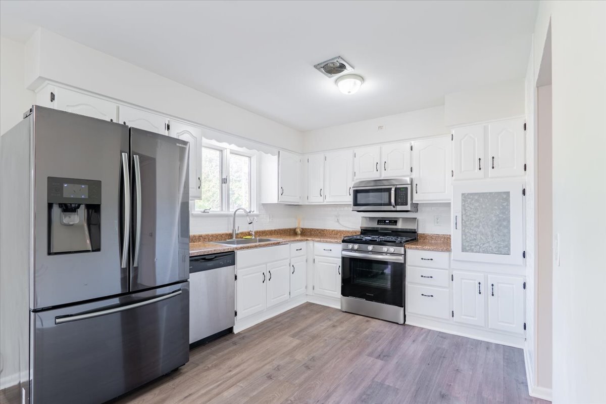 305 Highpoint Road Normal, IL 61761 - Photo 9 of 29 a kitchen with cabinets stainless steel appliances and wooden floor