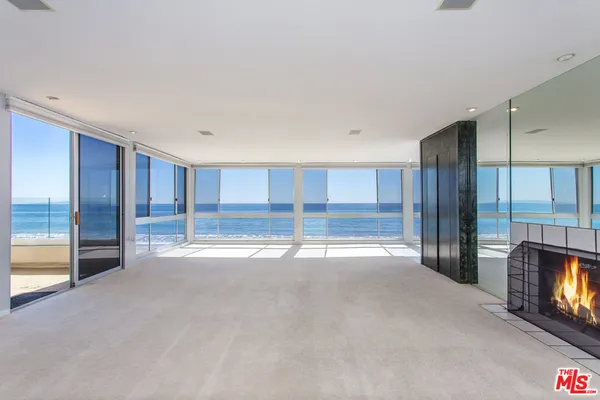 a view of an empty room with a fireplace and a window