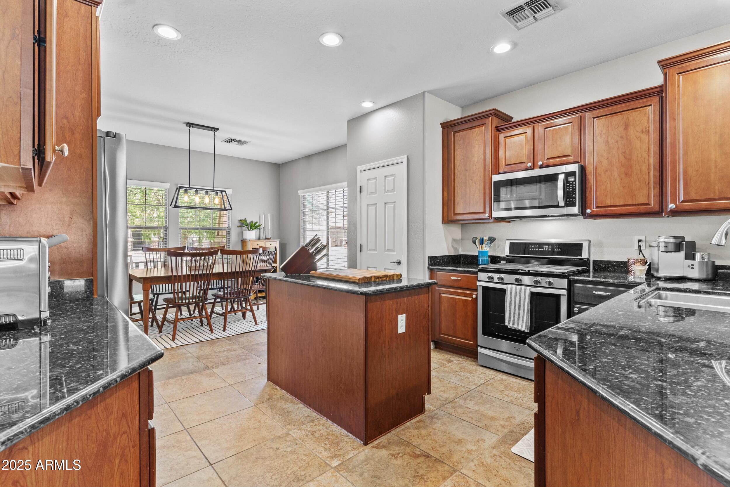 5303 West Hackamore Drive Phoenix, AZ 85083 - Photo 9 of 33 a kitchen with stainless steel appliances granite countertop a stove top oven a sink a counter top space and cabinets