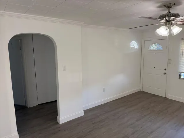 an empty room with wooden floor and mirror