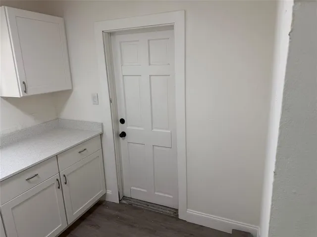 a utility room with wooden floor washer and dryer