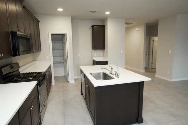 a view of a livingroom with a ceiling fan & windows