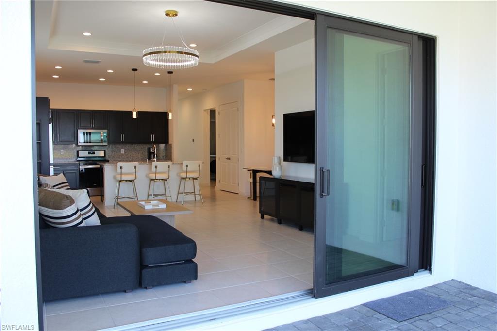 14601 Kingfisher Loop Naples, FL 34120 - Photo 16 of 20 a living room with furniture and a flat screen tv