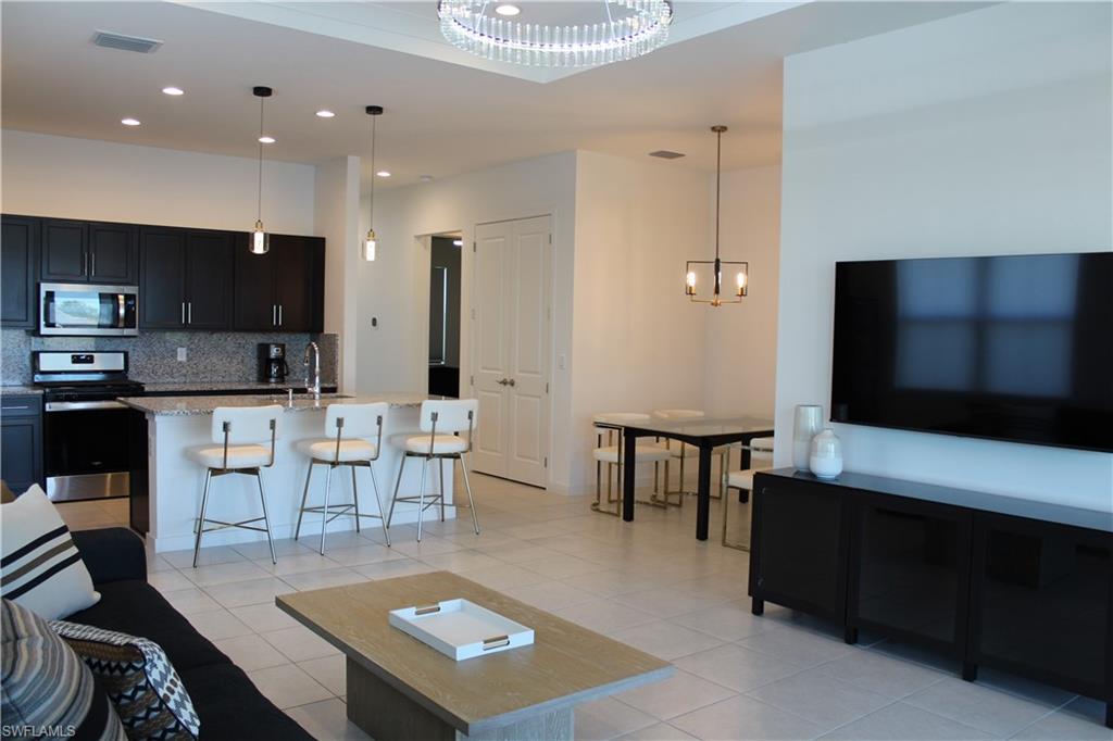 14601 Kingfisher Loop Naples, FL 34120 - Photo 5 of 20 a living room with furniture and a flat screen tv