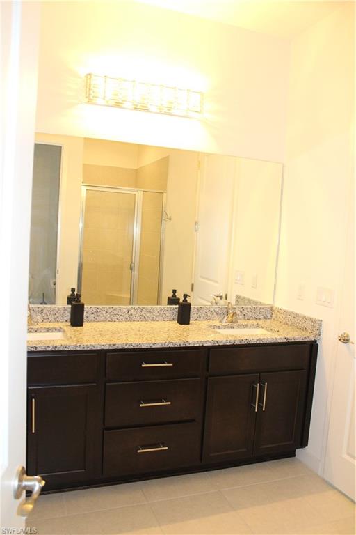 14601 Kingfisher Loop Naples, FL 34120 - Photo 10 of 20 a bathroom with a granite countertop sink and a mirror