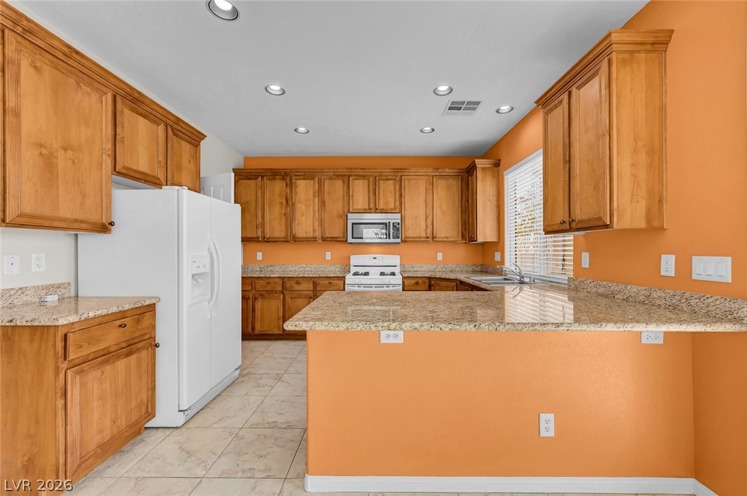 977 Sparkling Light Street Henderson, NV 89052 - Photo 5 of 75 This spacious kitchen offers ample cabinetry, extensive counter space, and a functional layout.