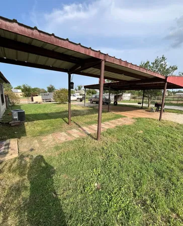 a backyard of a house with table and chairs a barbeque with wooden fence