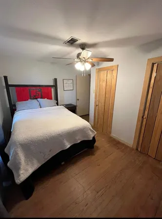 a bedroom with a large bed and a chandelier