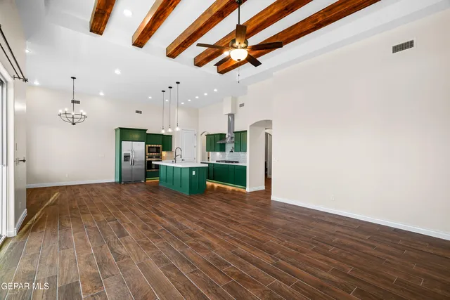 a kitchen with kitchen island wooden floors wooden cabinets and refrigerator