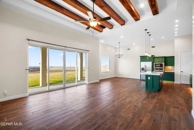 a kitchen with kitchen island a refrigerator wooden floor and a view of living room