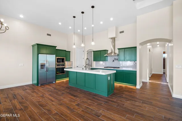 a kitchen with kitchen island a refrigerator sink and stove