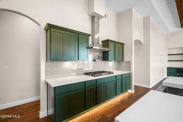 a large kitchen with stainless steel appliances a large counter top a sink a stove and a refrigerator