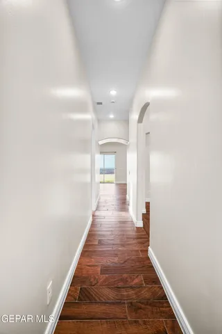 an empty room with wooden floor and window