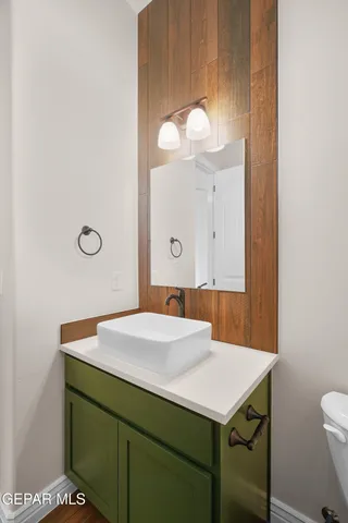 a bathroom with a sink a light fixture and a toilet