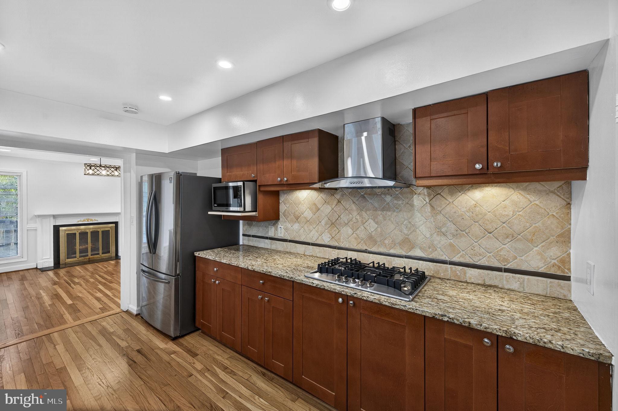 10600 Vantage Court Potomac, MD 20854 - Photo 18 of 91 a kitchen with stainless steel appliances granite countertop a refrigerator a stove and a wooden floors