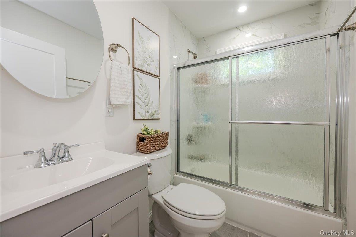 55 Hickory Road Rocky Point, NY 11778 - Photo 13 of 25 a bathroom with a shower sink vanity mirror and toilet
