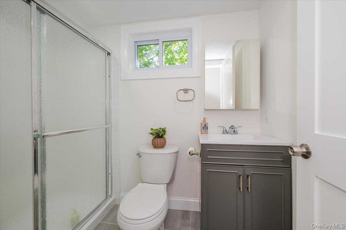 55 Hickory Road Rocky Point, NY 11778 - Photo 14 of 25 a bathroom with a toilet a sink a vanity and mirror