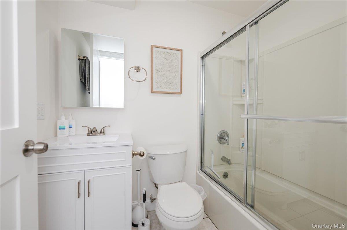 55 Hickory Road Rocky Point, NY 11778 - Photo 21 of 25 a bathroom with a toilet a sink a mirror a shower and vanity