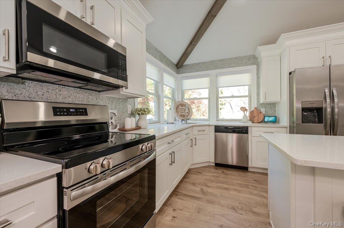 55 Hickory Road Rocky Point, NY 11778 - Photo 7 of 25 a kitchen with a stove microwave and cabinets