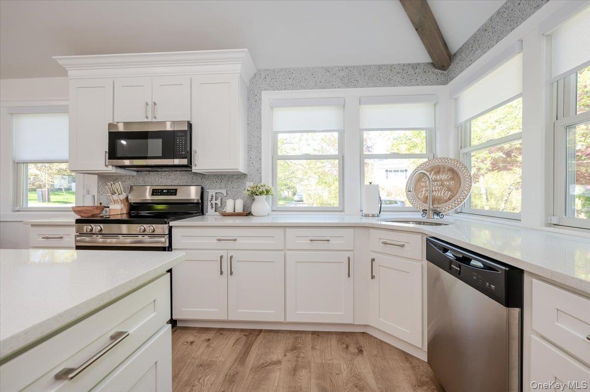 55 Hickory Road Rocky Point, NY 11778 - Photo 8 of 25 a kitchen with granite countertop white cabinets and stainless steel appliances