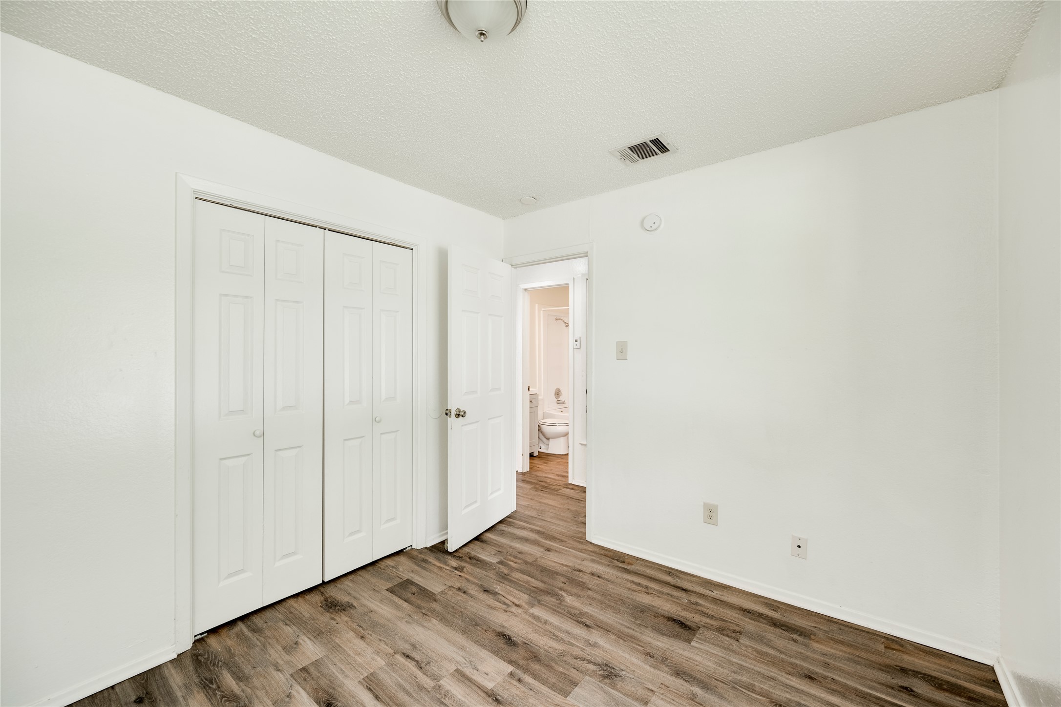 7918 West Gate Boulevard Austin, TX 78745 - Photo 8 of 31 Laminate wood flooring grounds this naturally illuminated bedroom with convenient en-suite bathroom access.