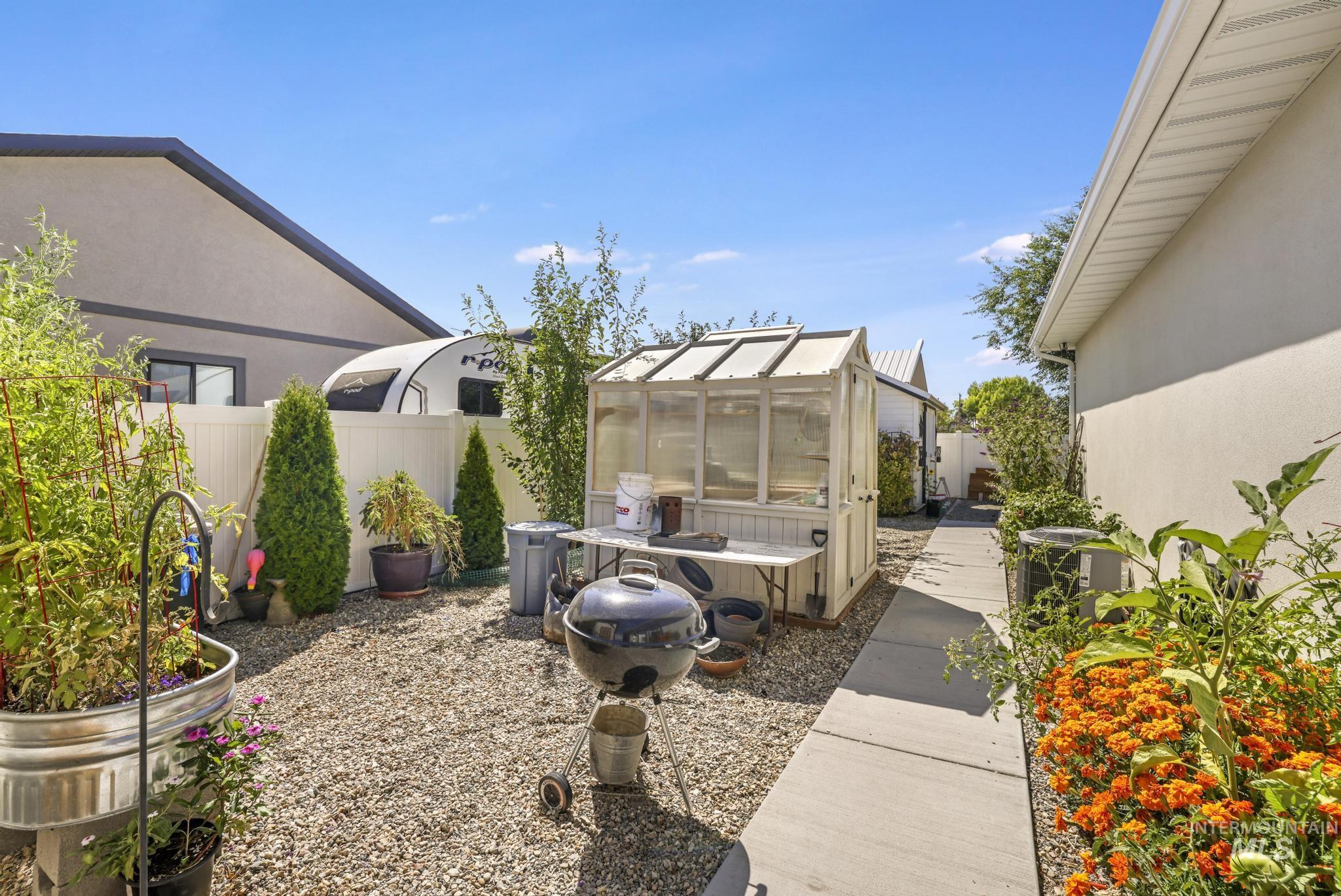 1384 Jump Street Twin Falls, ID 83301 - Photo 30 of 37 View of patio featuring greenhouse, garden beds