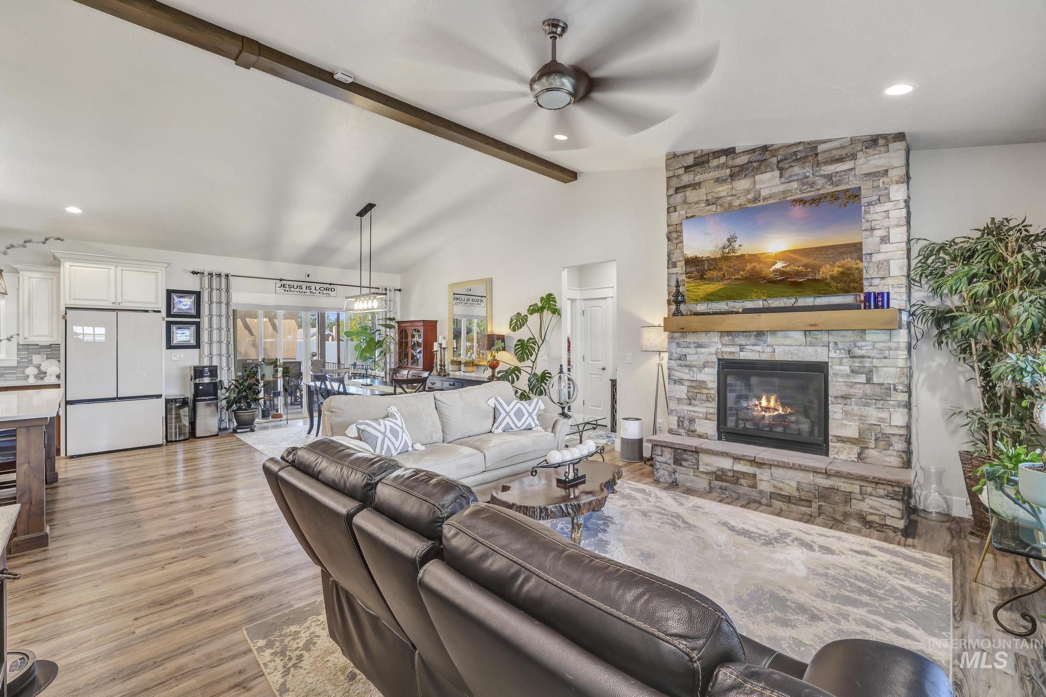 1384 Jump Street Twin Falls, ID 83301 - Photo 5 of 37 Living area featuring light wood-type flooring, beamed ceiling, ceiling fan, a stone fireplace, and recessed lighting