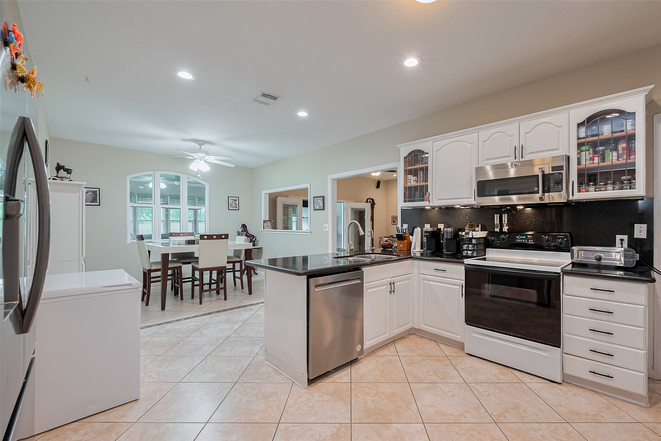 2499 Southline Road Conroe, TX 77384 - Photo 16 of 48 a kitchen with stainless steel appliances granite countertop a stove top oven a sink a dining table and chairs