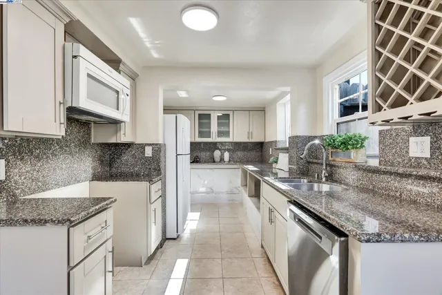 a kitchen with stainless steel appliances granite countertop a sink stove and cabinets