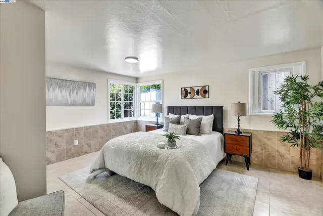 a bedroom with bed and paintings on the wall