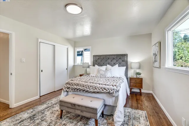 a bedroom with a bed and wooden floor