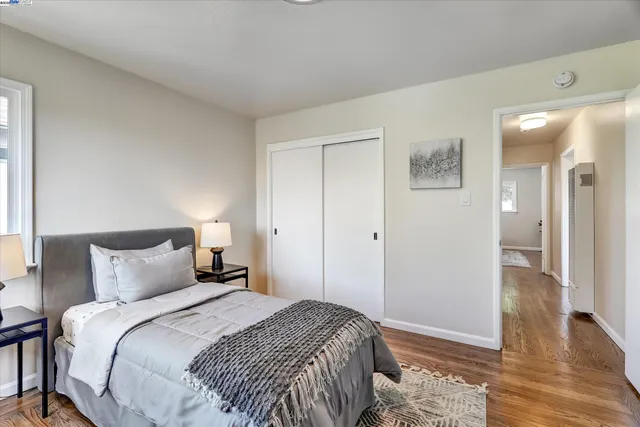 a bedroom with a bed table chair and a window