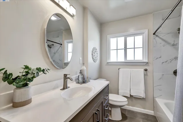a bathroom with a bathtub shower sink vanity and toilet