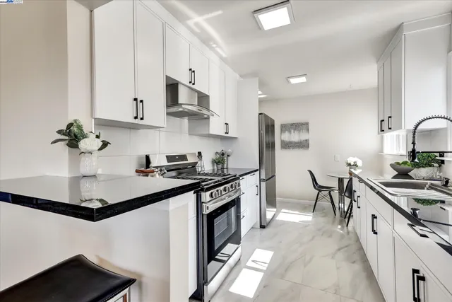 a kitchen with sink and view of living room