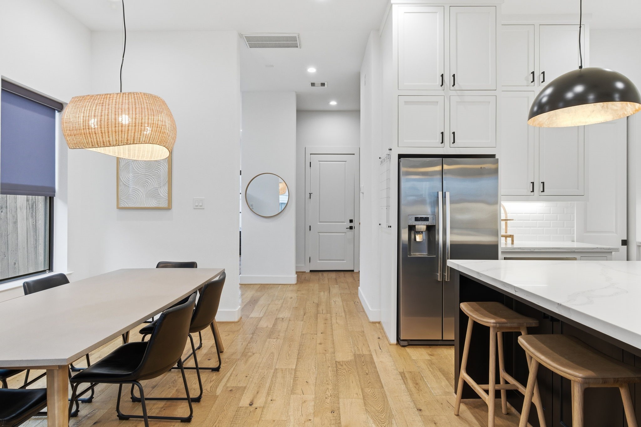 504 Oxford Street Houston, TX 77007 - Photo 16 of 47 This view highlights the connection between the dining area and kitchen, keeping everything open yet well defined. The oversized island offers additional seating, while tall cabinetry provides ample storage. It’s a layout designed for both everyday routines and hosting with ease.