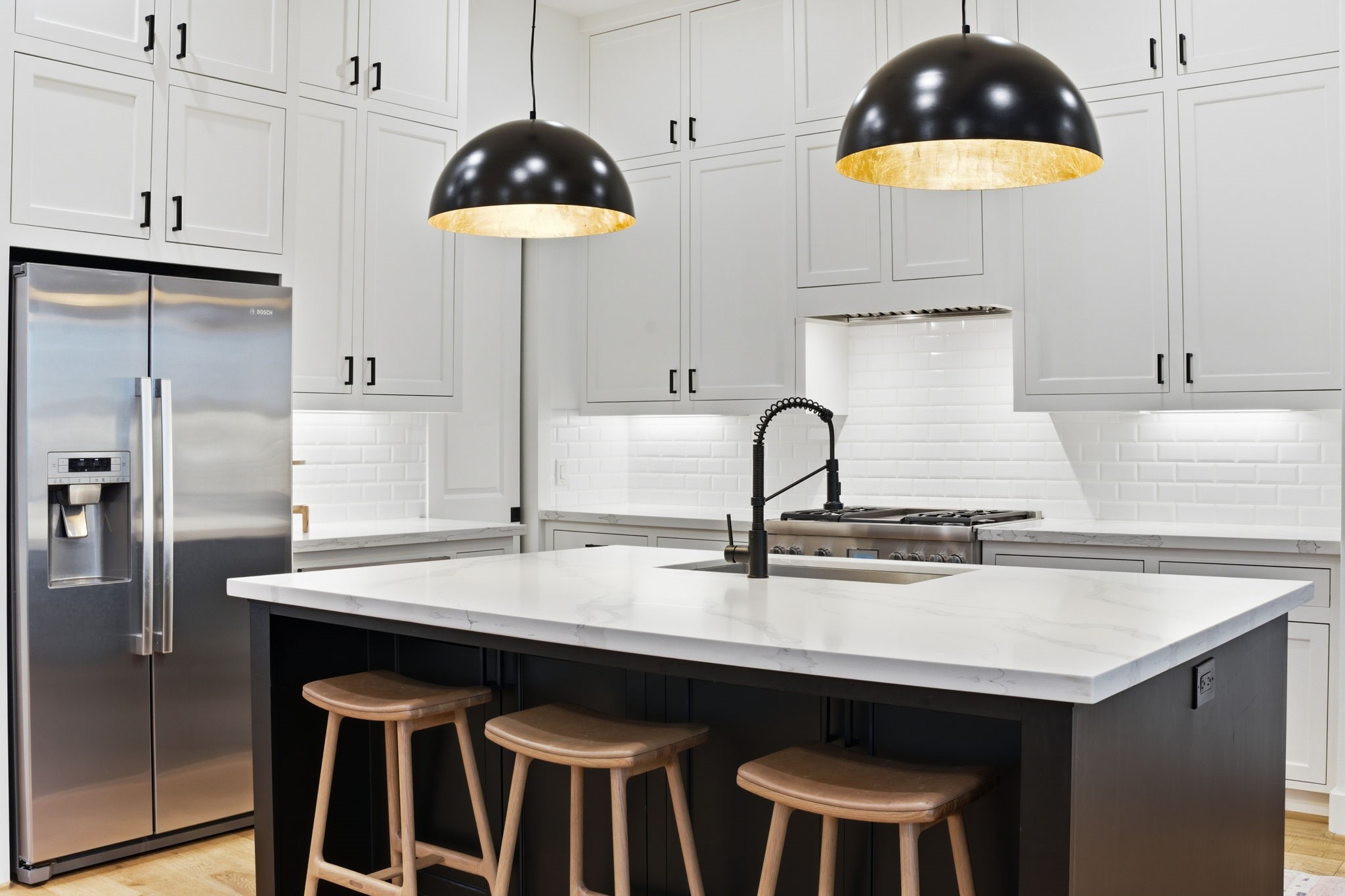 504 Oxford Street Houston, TX 77007 - Photo 17 of 47 The kitchen anchors the space with a large island, quartz countertops, and abundant cabinetry. Stainless appliances and statement pendant lighting add warmth and contrast. Generous prep space and seating make it as functional as it is inviting.