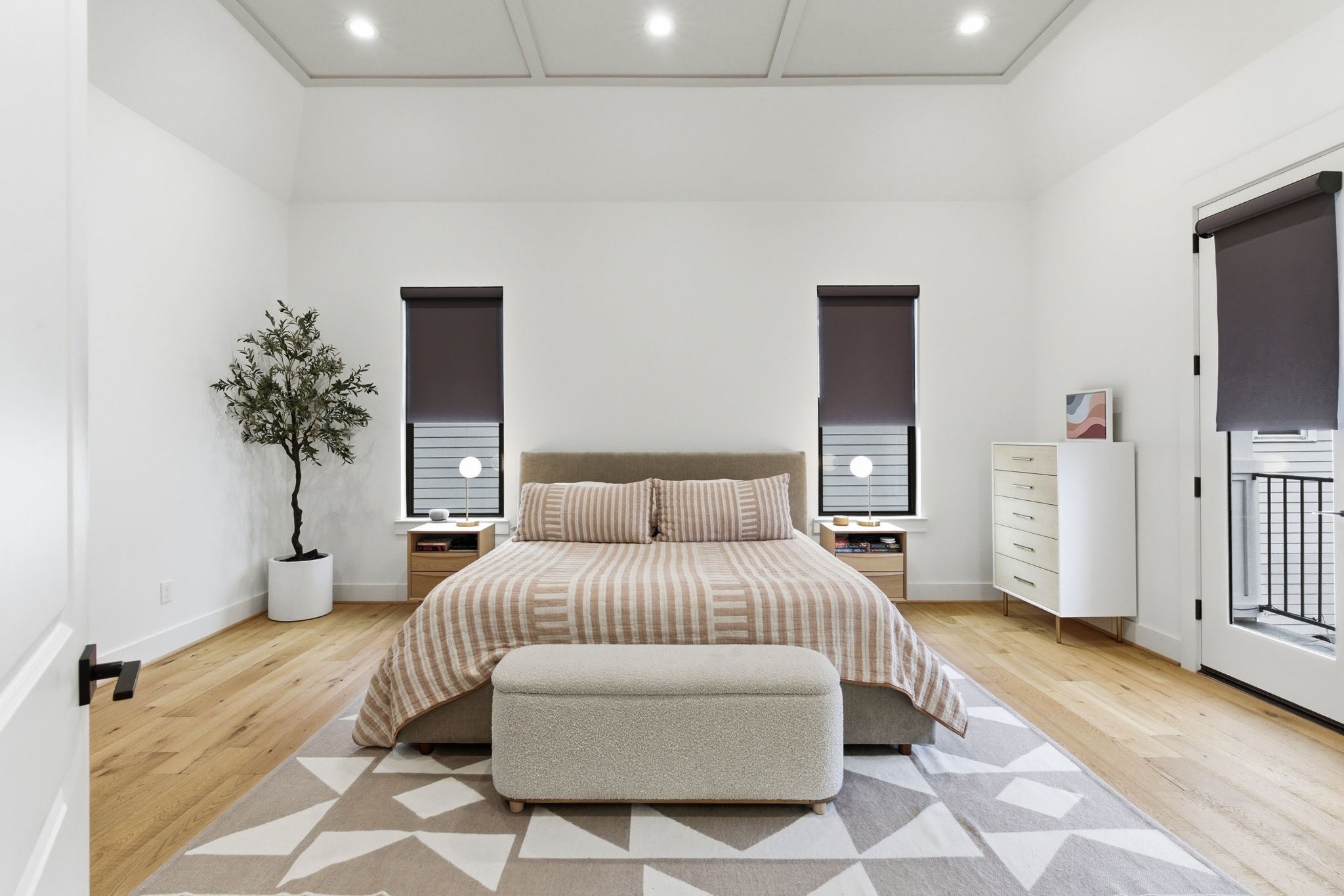 504 Oxford Street Houston, TX 77007 - Photo 26 of 47 The primary bedroom feels calm and spacious, with beautiful ceiling details high & hardwood floors (no carpet in this house). Large windows and French doors bring in natural light and provide access to a private balcony. The cleanliness and neutral palette create a peaceful retreat.