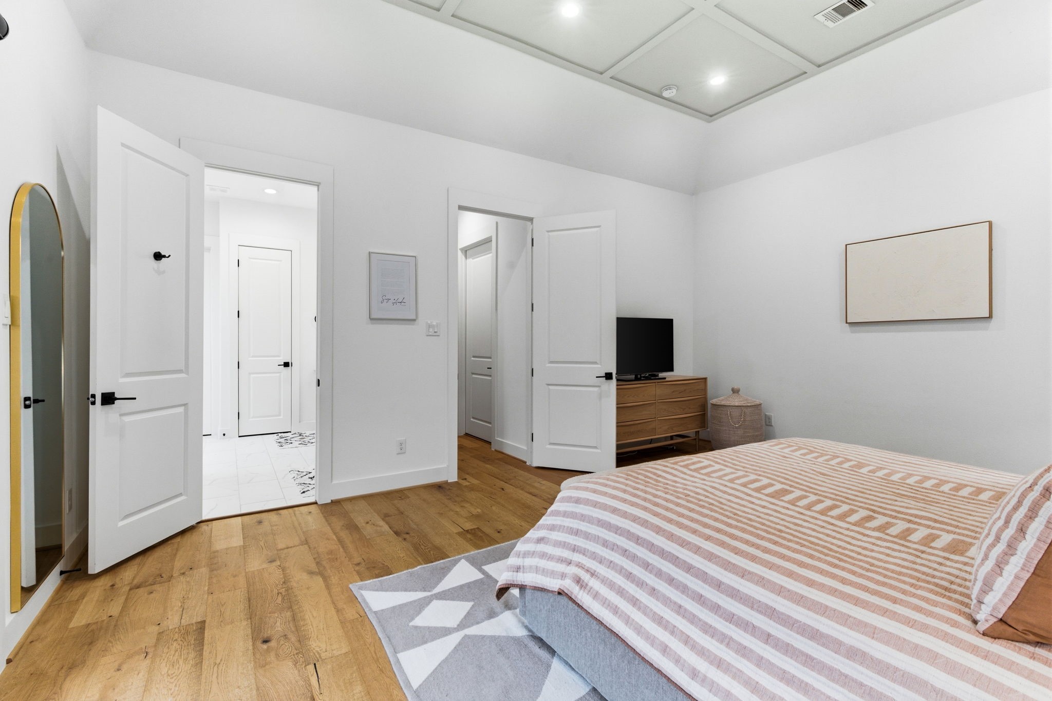 504 Oxford Street Houston, TX 77007 - Photo 32 of 47 The primary bedroom layout flows seamlessly into the ensuite bath and closet areas. Multiple doorways provide easy access while maintaining privacy. Every element feels intentional and well planned. Note the beautiful ceiling details.