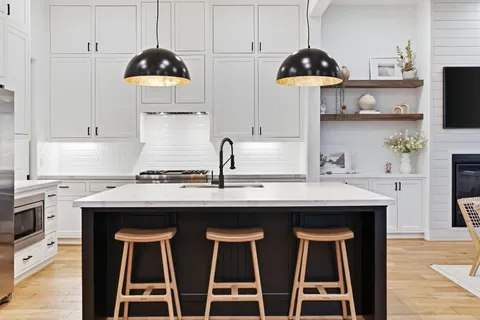 a living room with stainless steel appliances kitchen island a table chairs and a kitchen view
