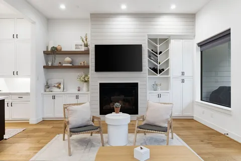 a living room with furniture wooden floor and a flat screen tv
