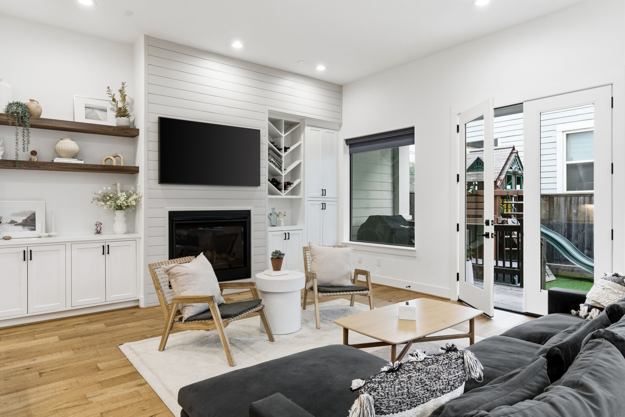 504 Oxford Street Houston, TX 77007 - Photo 10 of 47 Custom built-ins surround the fireplace, adding both character and practical storage. The shiplap accent wall adds subtle texture without overwhelming the space. It’s a warm, inviting setting for everyday living.
