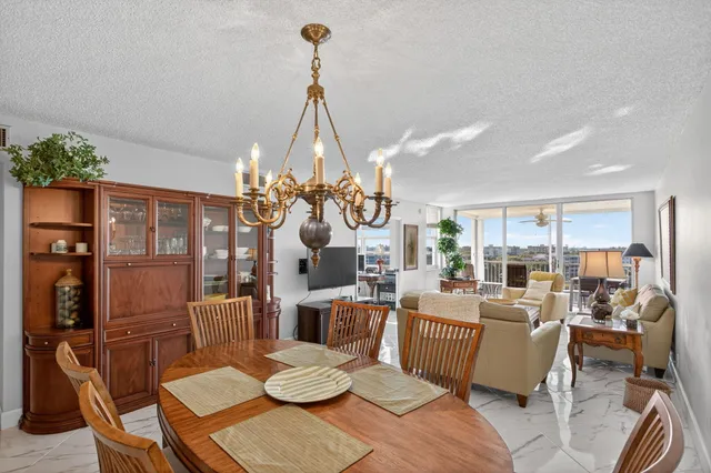 a view of a dining room with furniture a chandelier and wooden floor