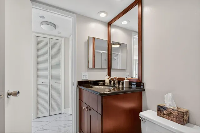 a bathroom with a sink a toilet and a mirror