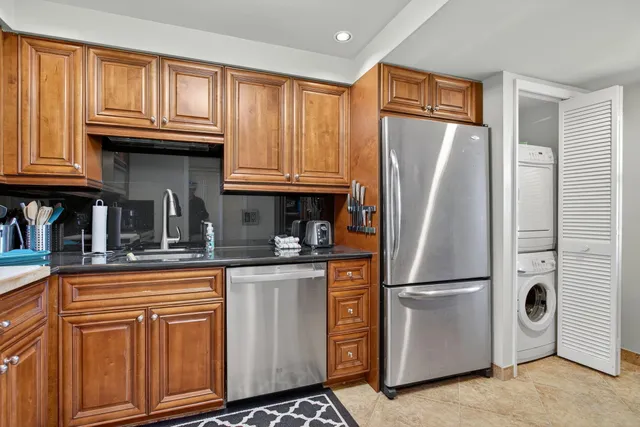 a kitchen with granite countertop a refrigerator stove and cabinets