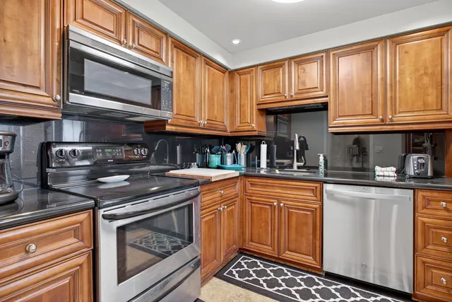 a kitchen with stainless steel appliances granite countertop a stove microwave and cabinets